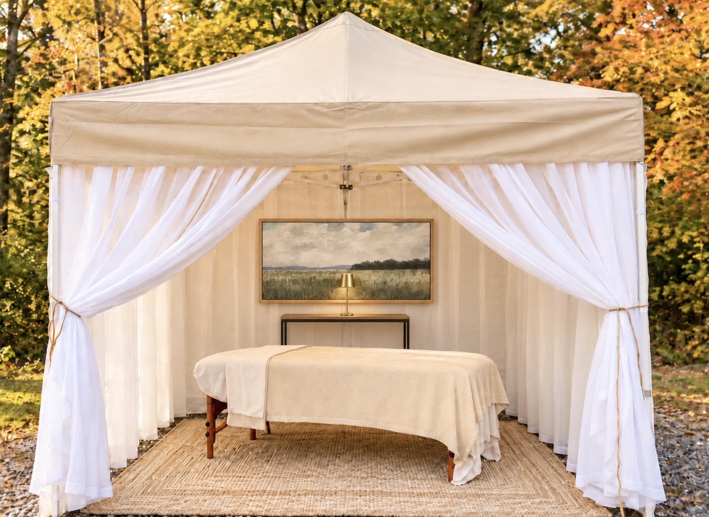 The Signature Spa Tent with white curtains and a cream massage table surrounded by autumn foliage
